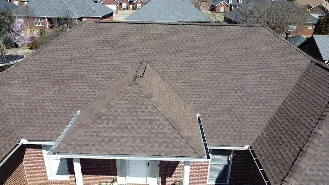 Brown shingle roof on a residential house.  Exterior view of a house with several roof sections.