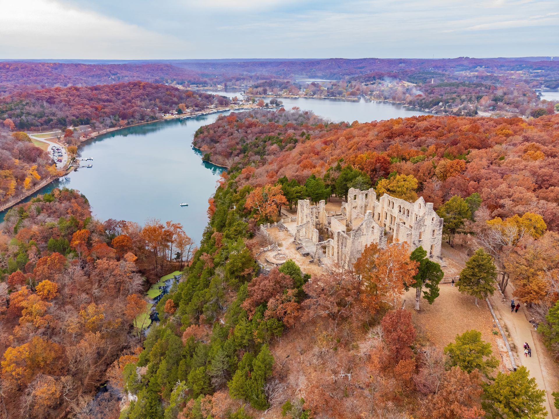 An aerial view of a lake surrounded by trees and a cliff.