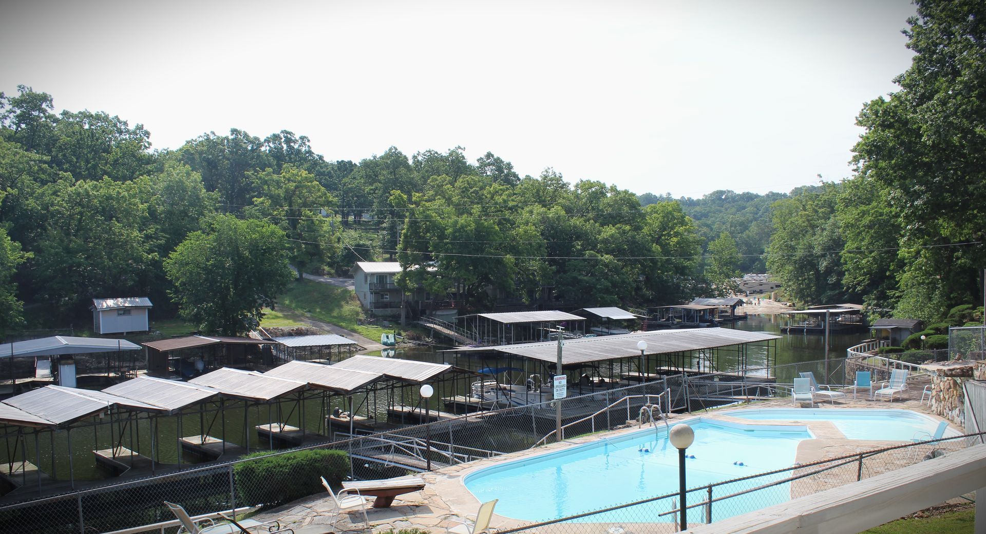 An aerial view of a swimming pool surrounded by houses and trees