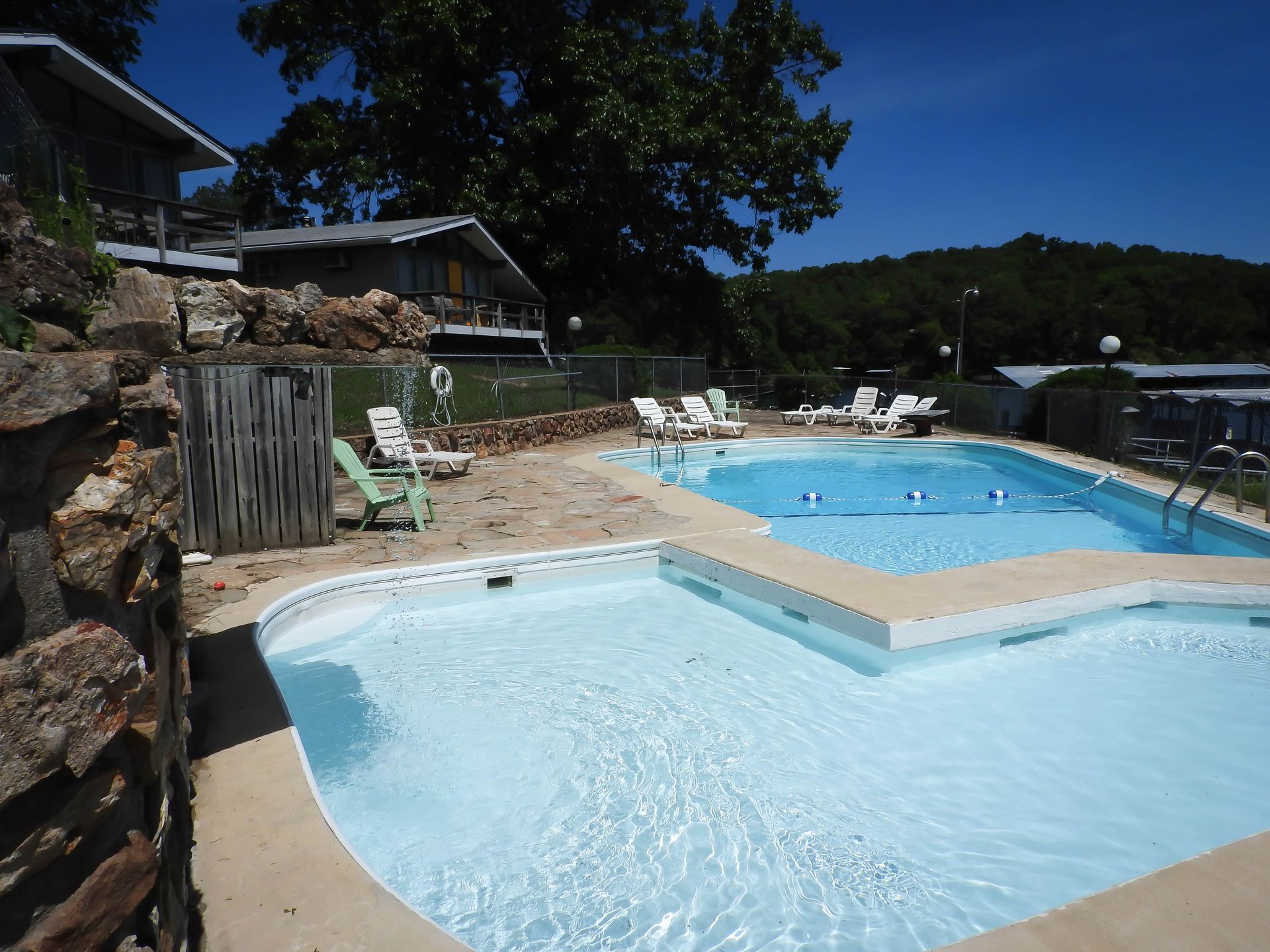 A large swimming pool with a lot of chairs around it