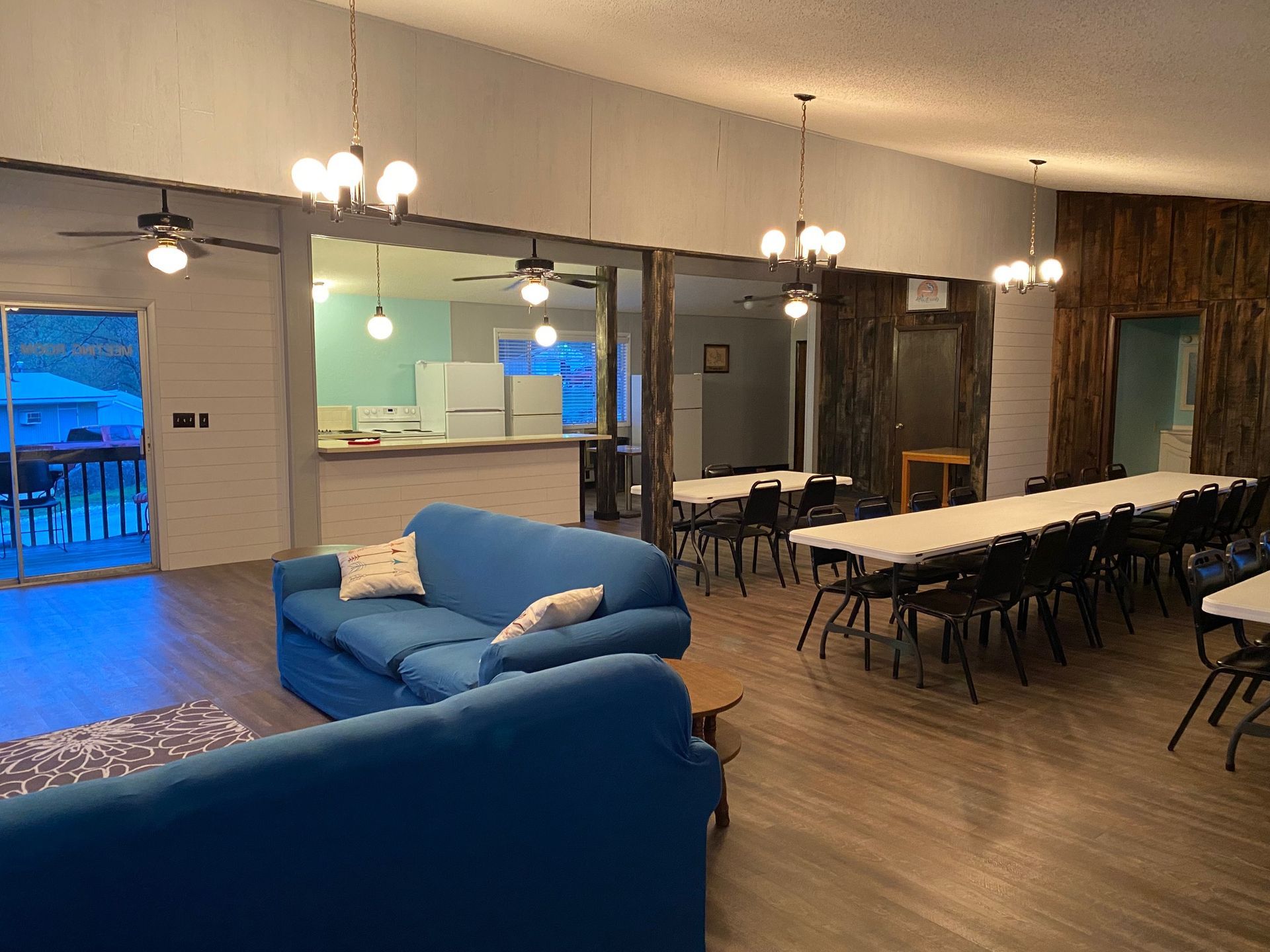 A living room with a blue couch , tables and chairs.