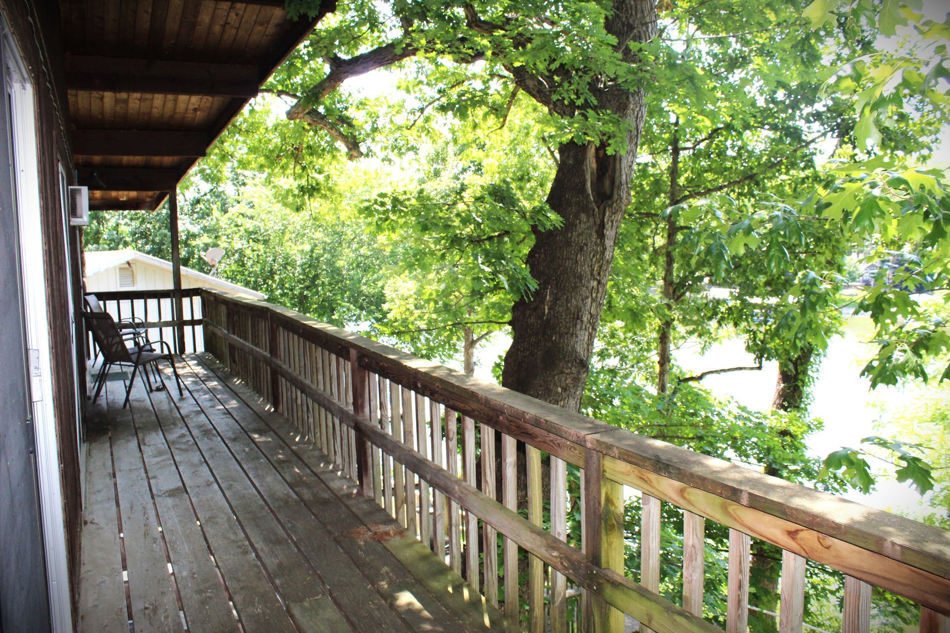 A wooden deck with a view of trees and a river