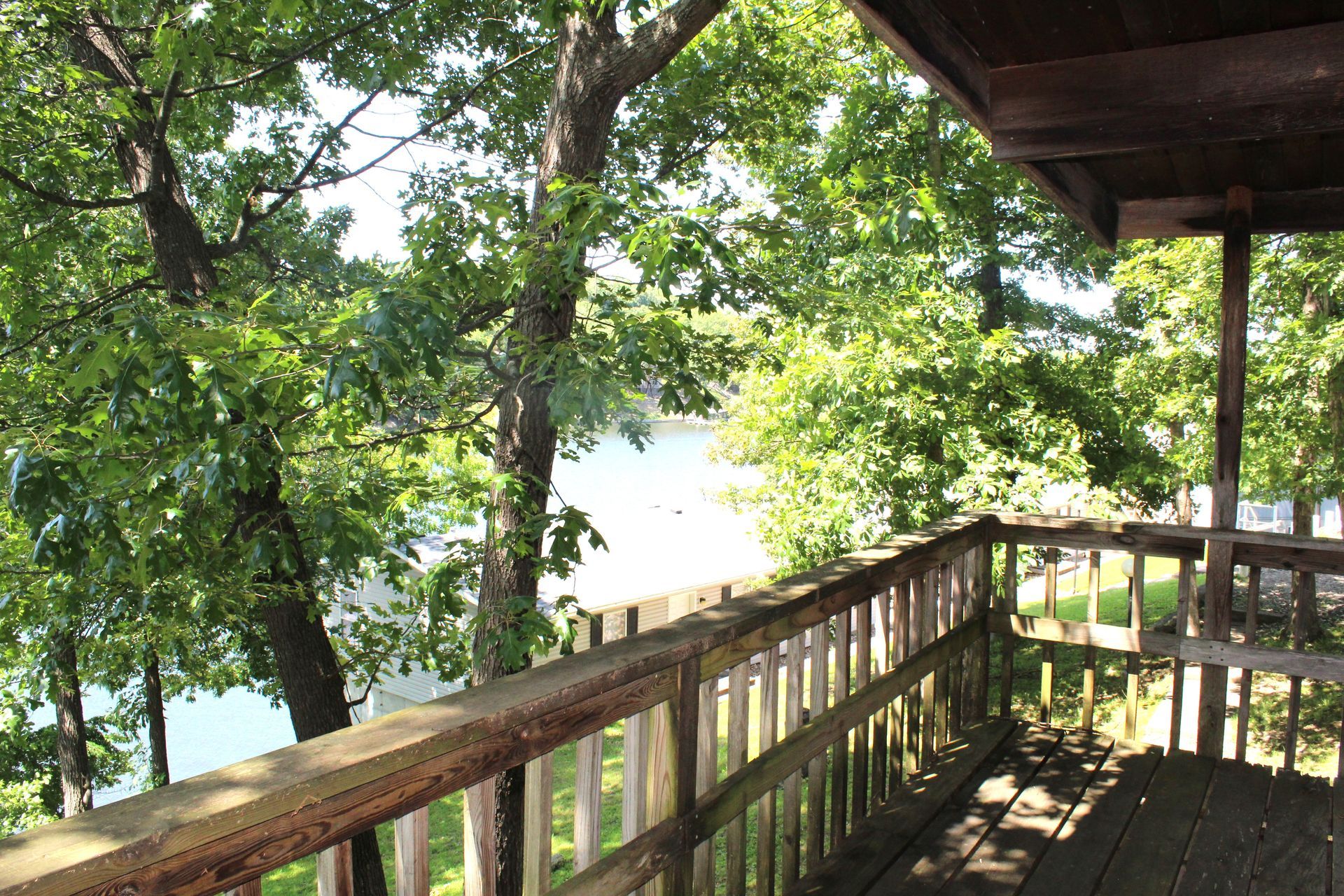 A wooden deck overlooking a lake with trees in the background