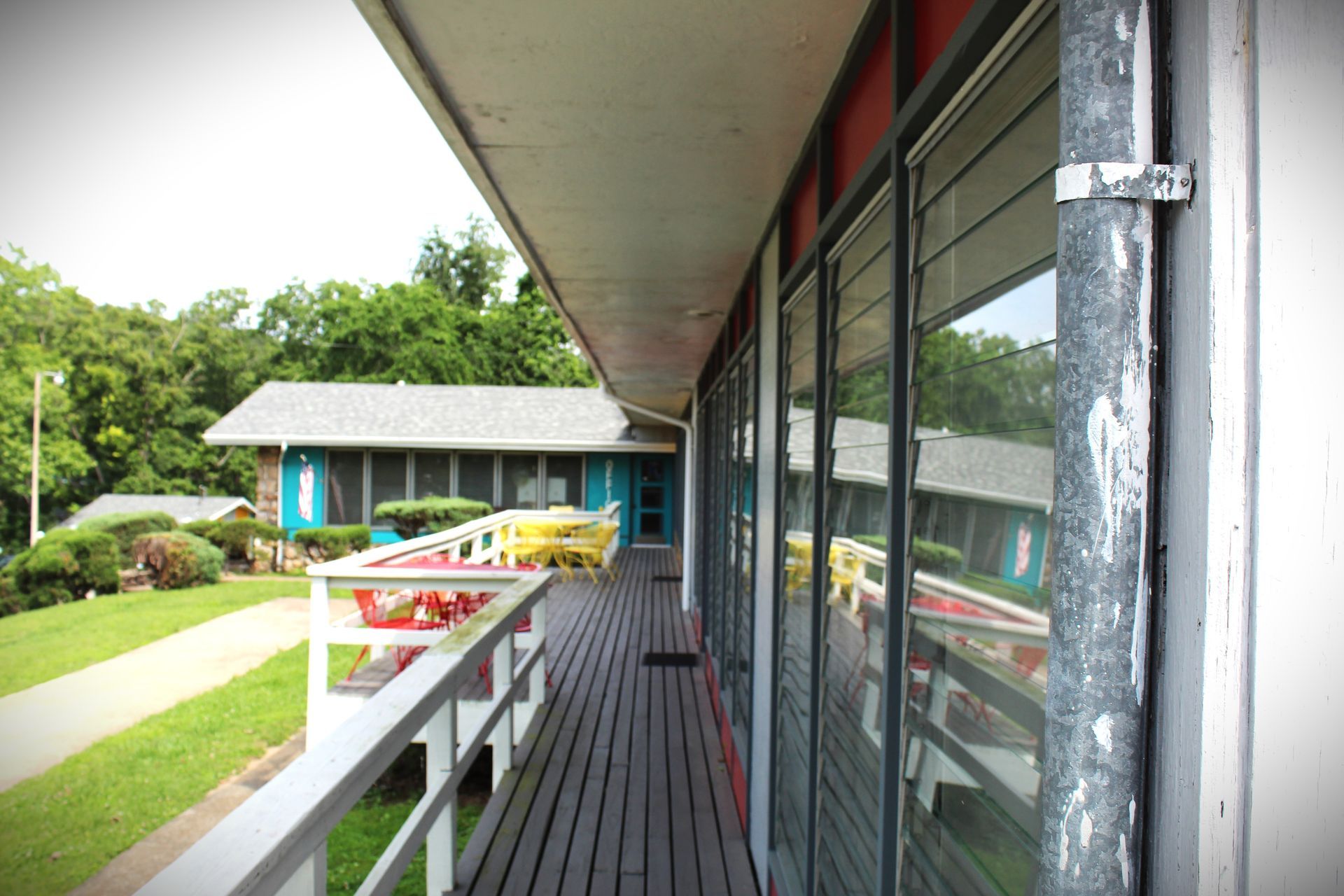 A balcony with a reflection of a house in the windows