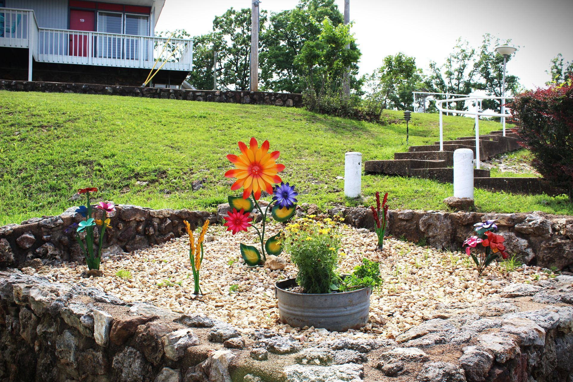 A garden with flowers and a house in the background
