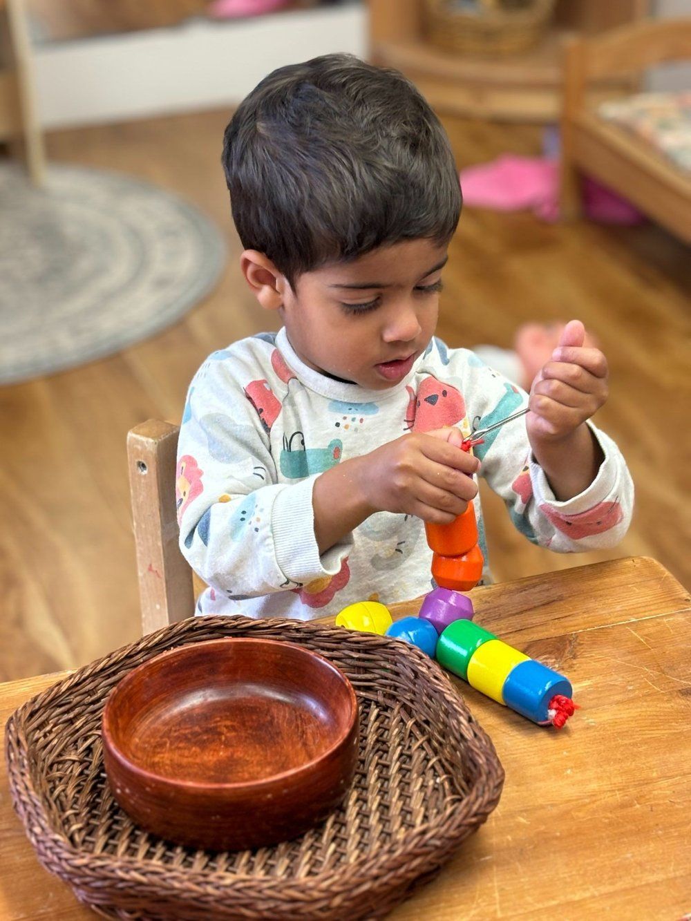 A young boy is sitting at a table playing with a toy.