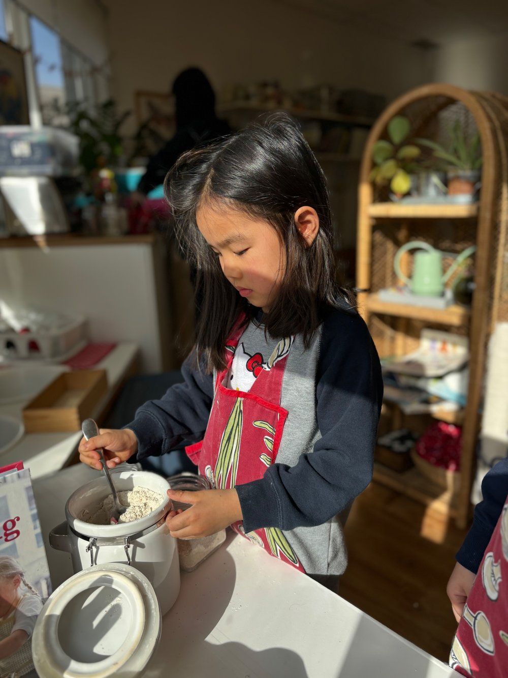 A little girl is preparing food in a kitchen.