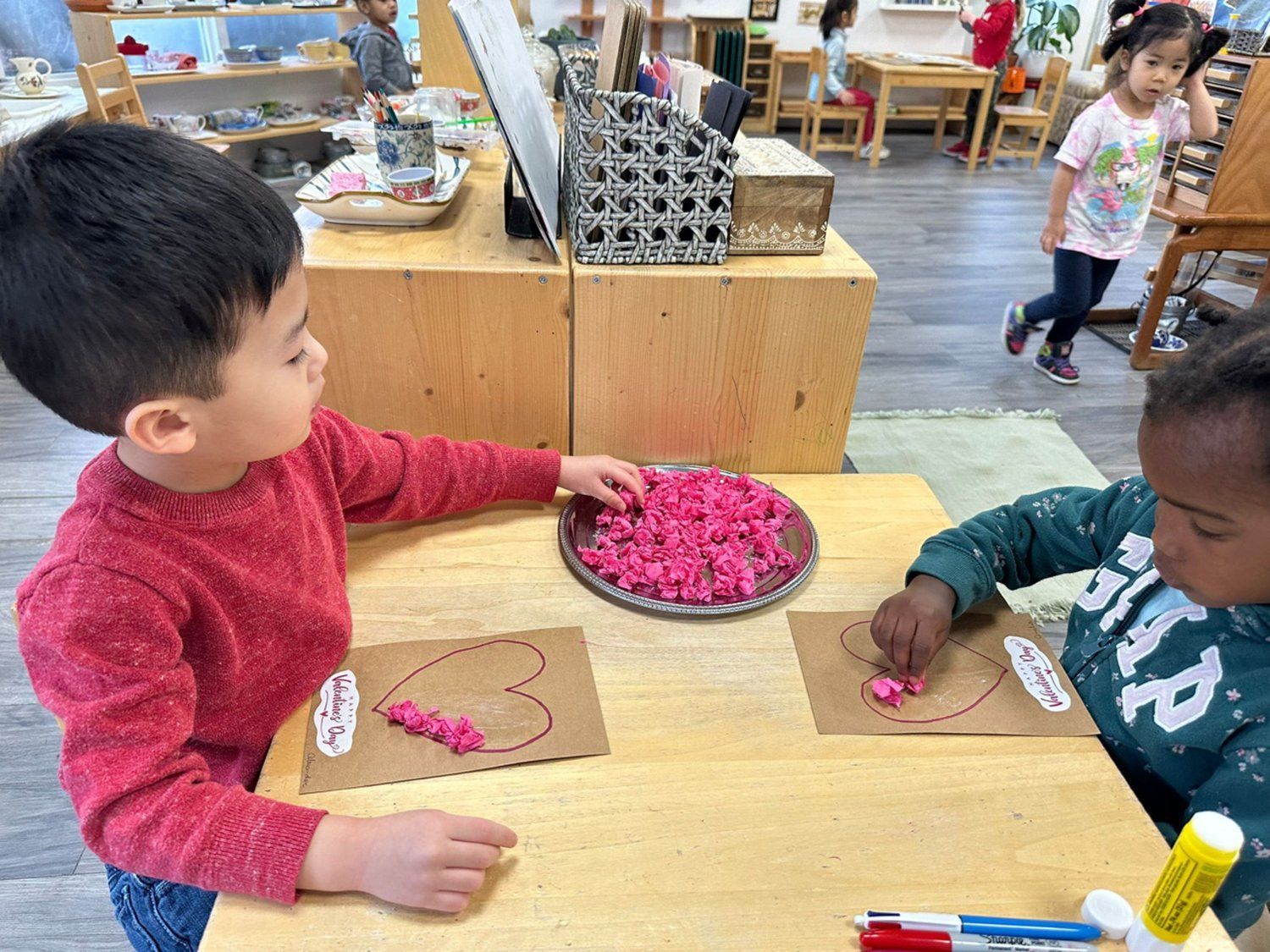 A boy and a girl are sitting at a table in a classroom.
