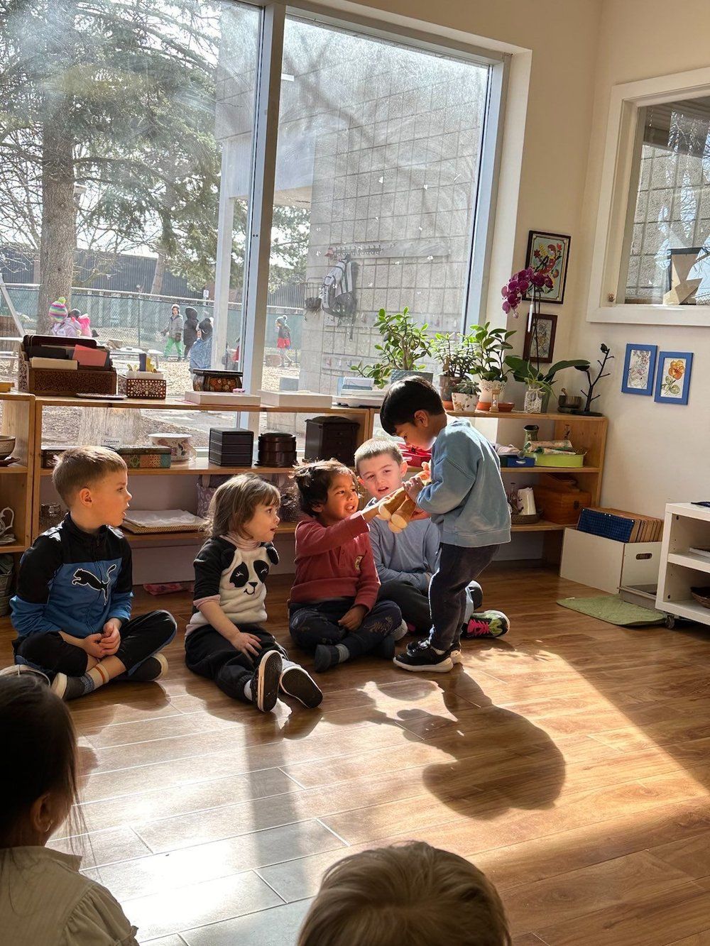 A group of children are sitting on the floor in a room.