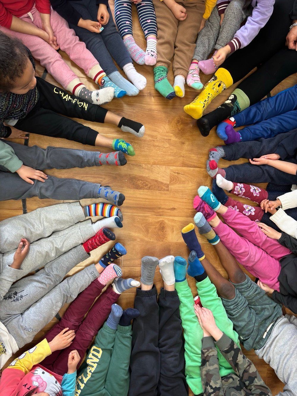 A group of children are laying on the floor wearing colorful socks.