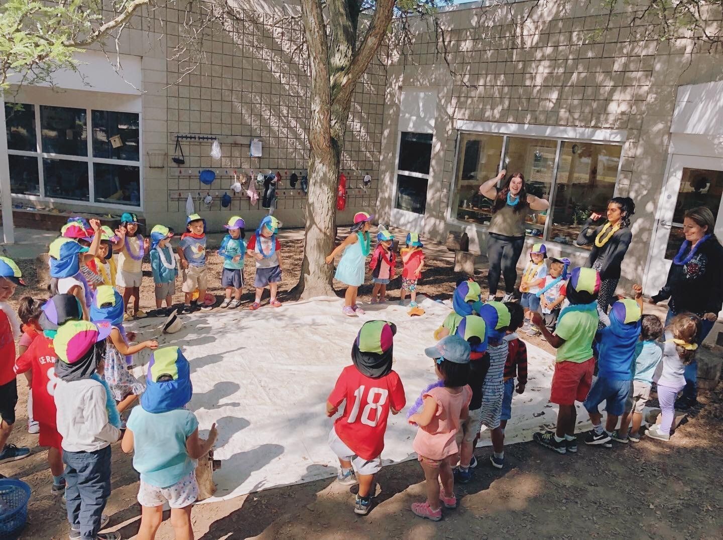 A group of children are standing in a circle in front of a building.