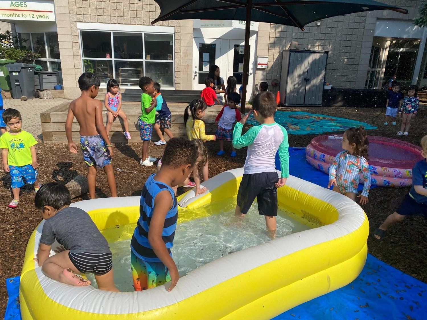 A group of children are playing in an inflatable pool.