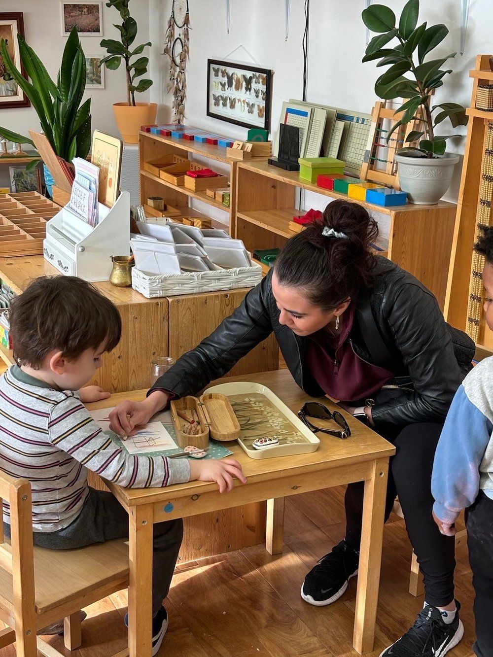 A woman is sitting at a table with a child.