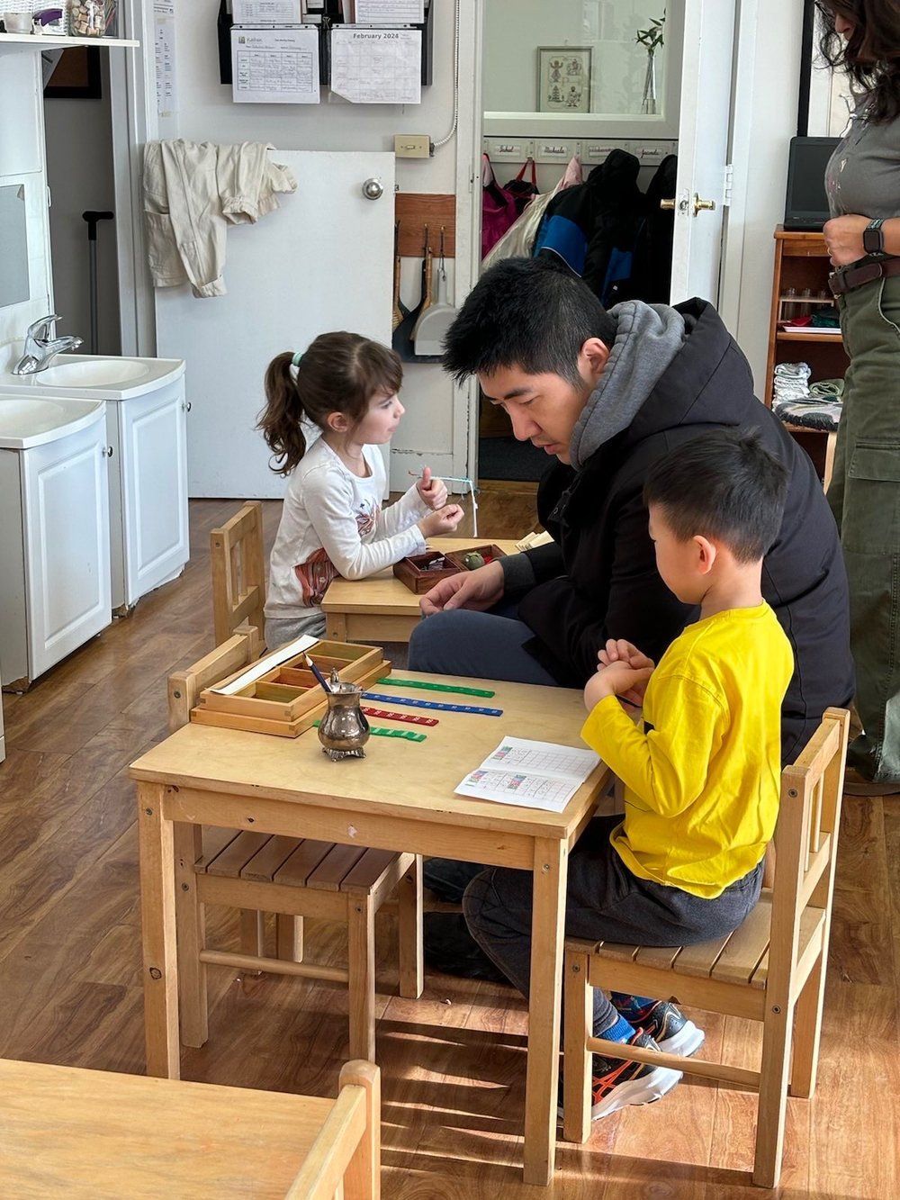 A man is sitting at a table with two children.