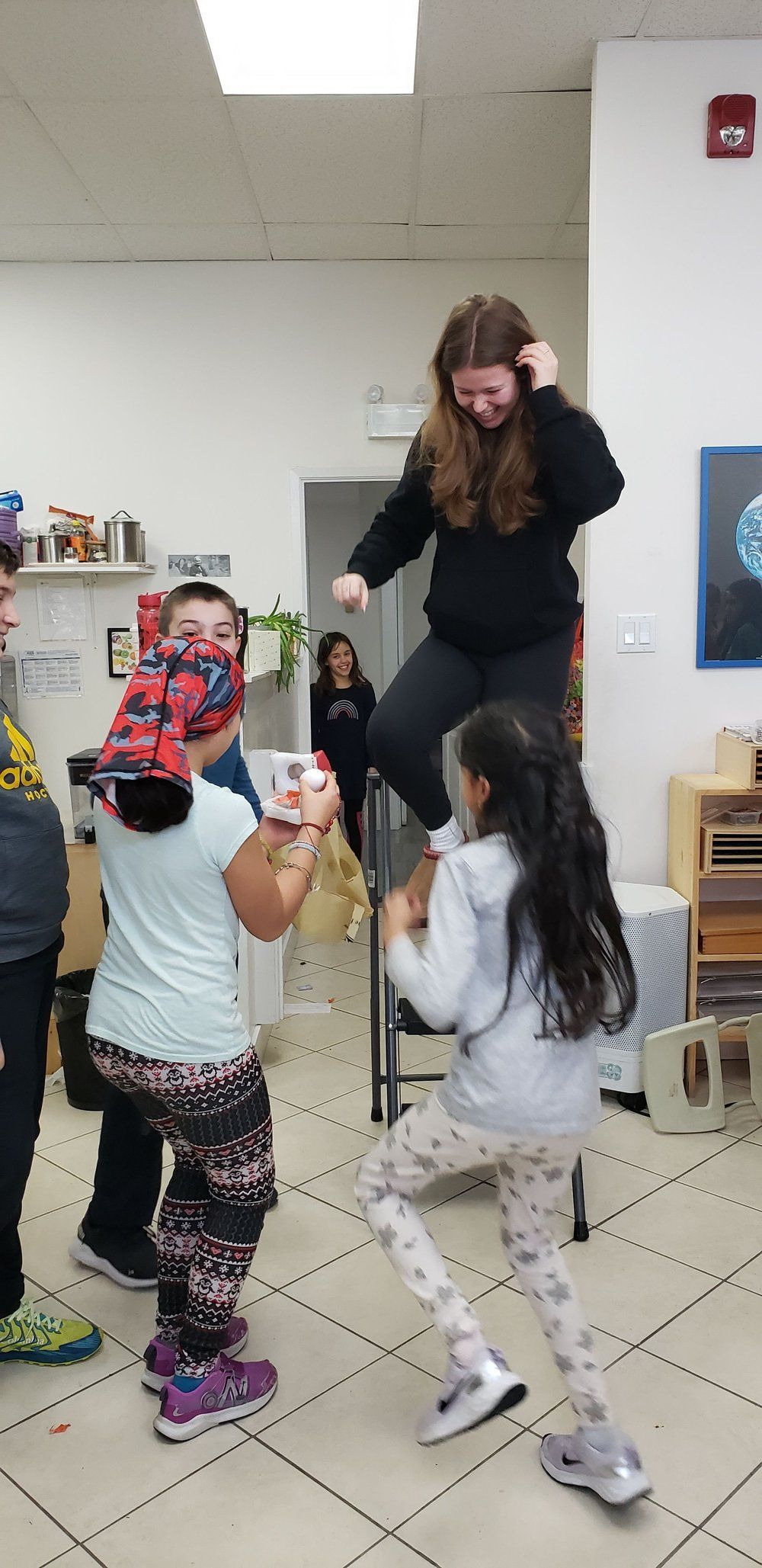 A group of children are playing a game in a room.