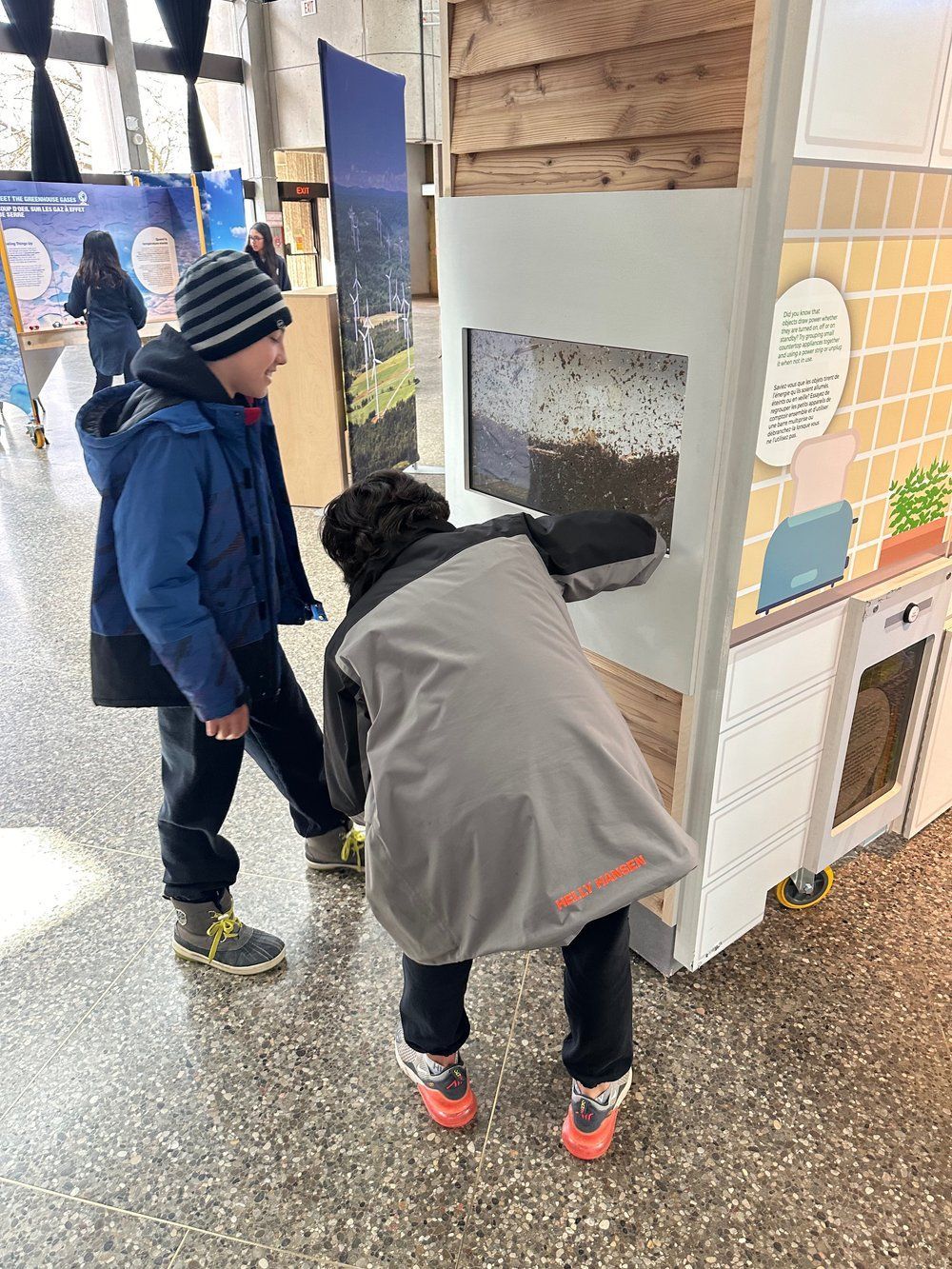 Two young boys are looking at a display in a museum.