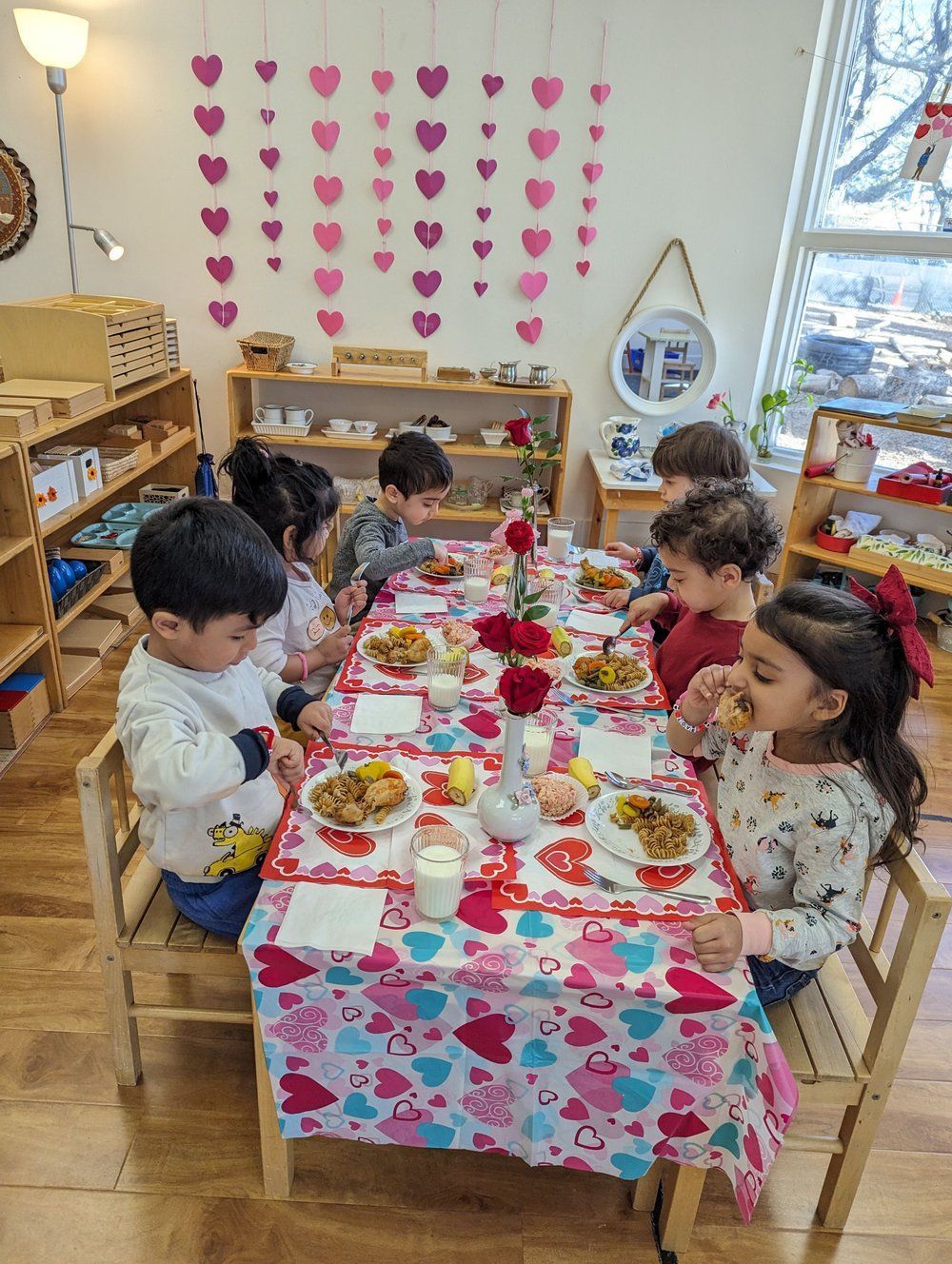 A group of children are sitting at a table eating food.