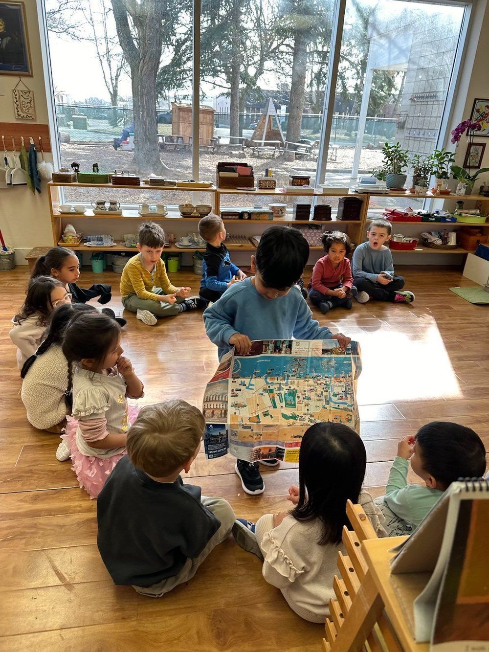 A group of children are sitting on the floor in a classroom.
