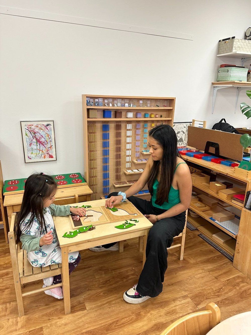 A woman is sitting at a table with two children.
