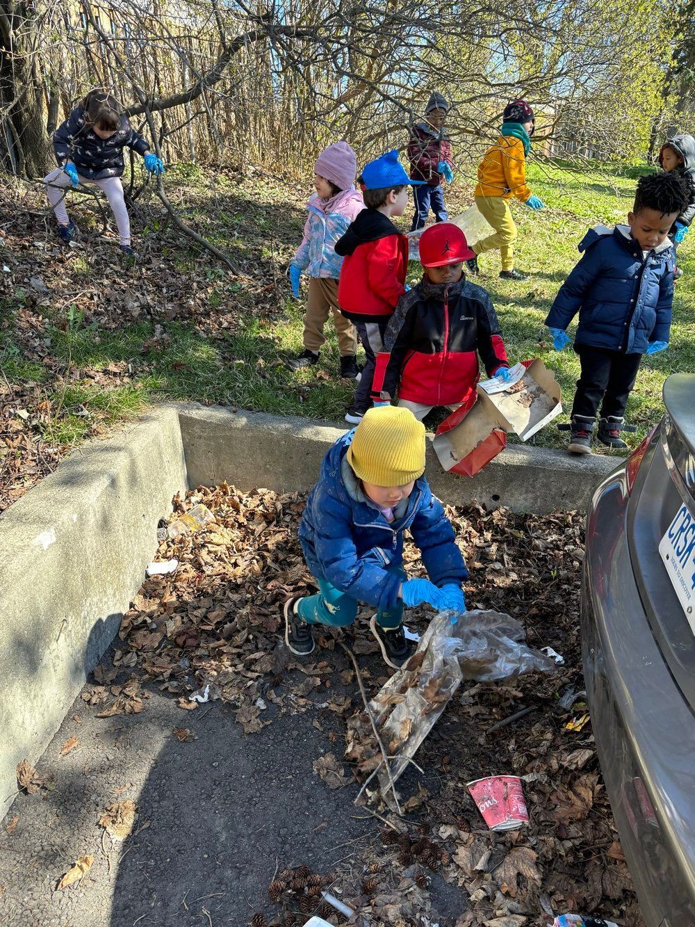A group of children are picking up trash from the ground.