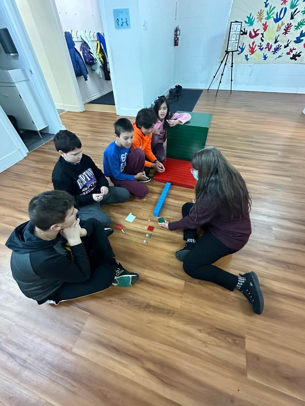 A group of children are sitting on the floor playing with toys.