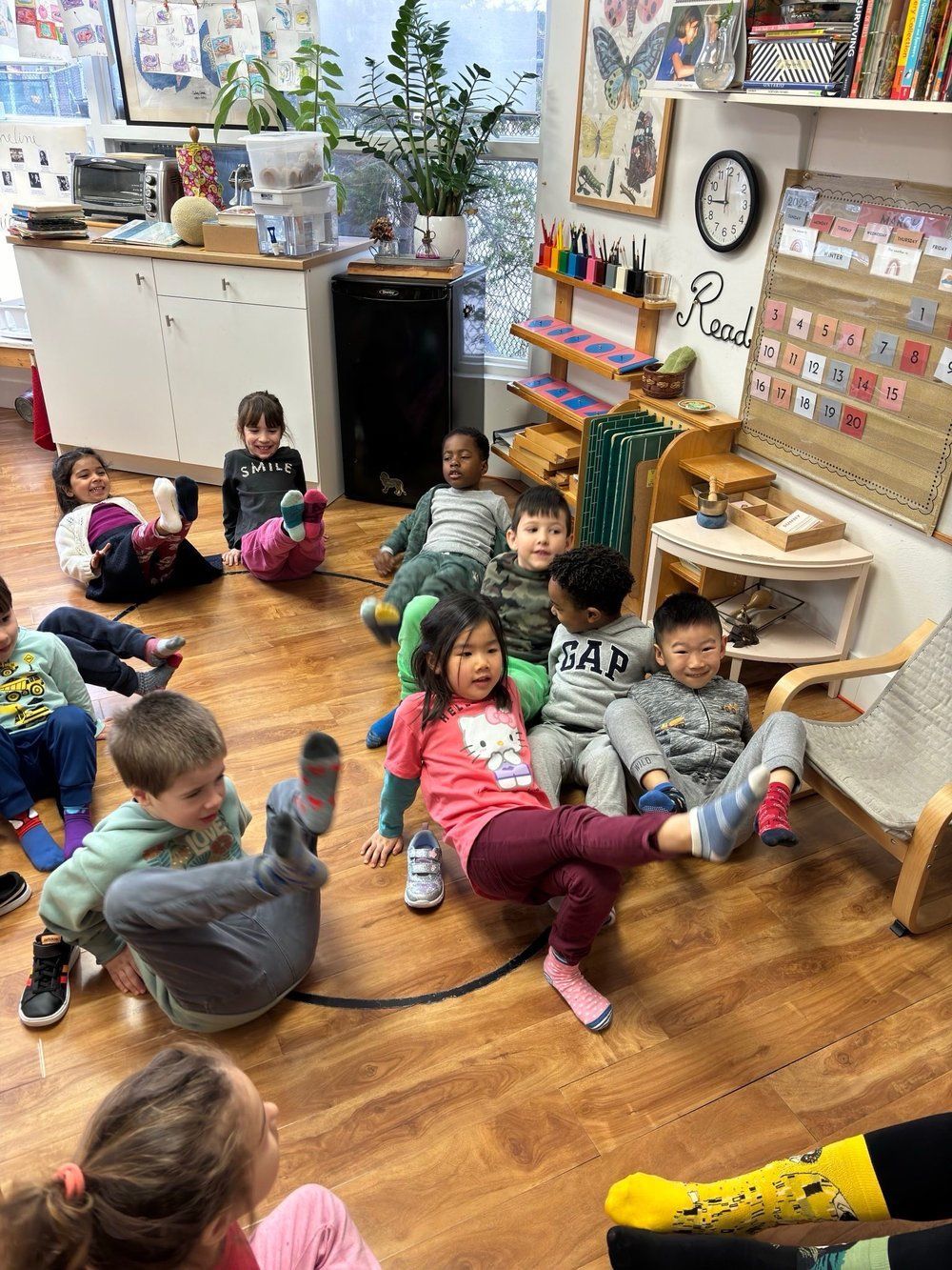 A group of children are sitting on the floor in a classroom.
