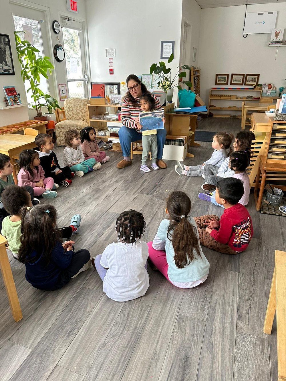 A woman is reading a book to a group of children.
