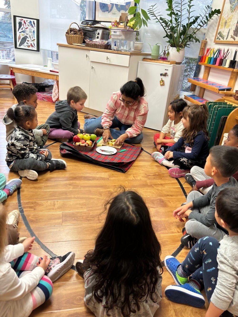 A group of children are sitting on the floor in a circle.