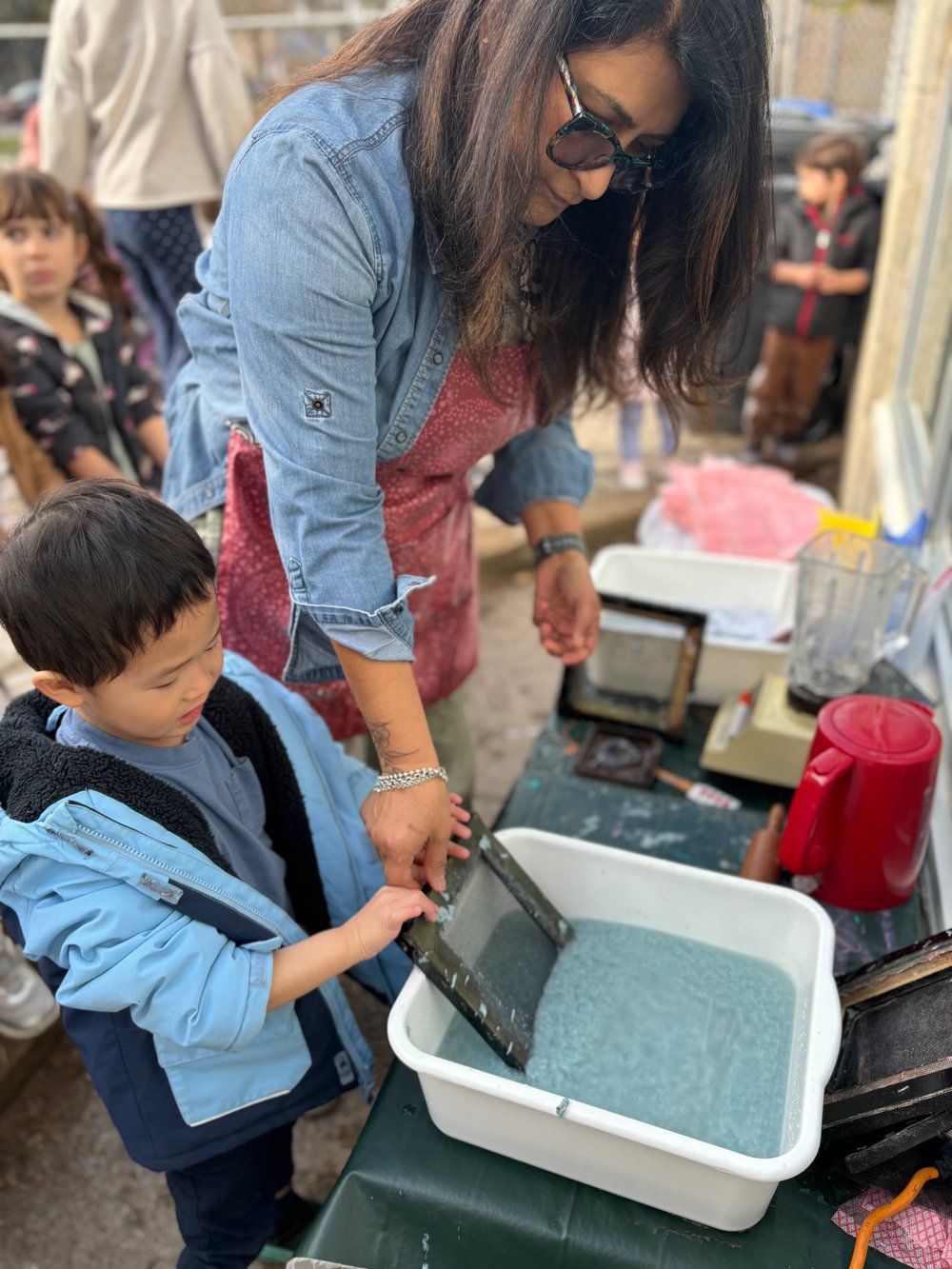 A woman and a child are playing with a tablet.