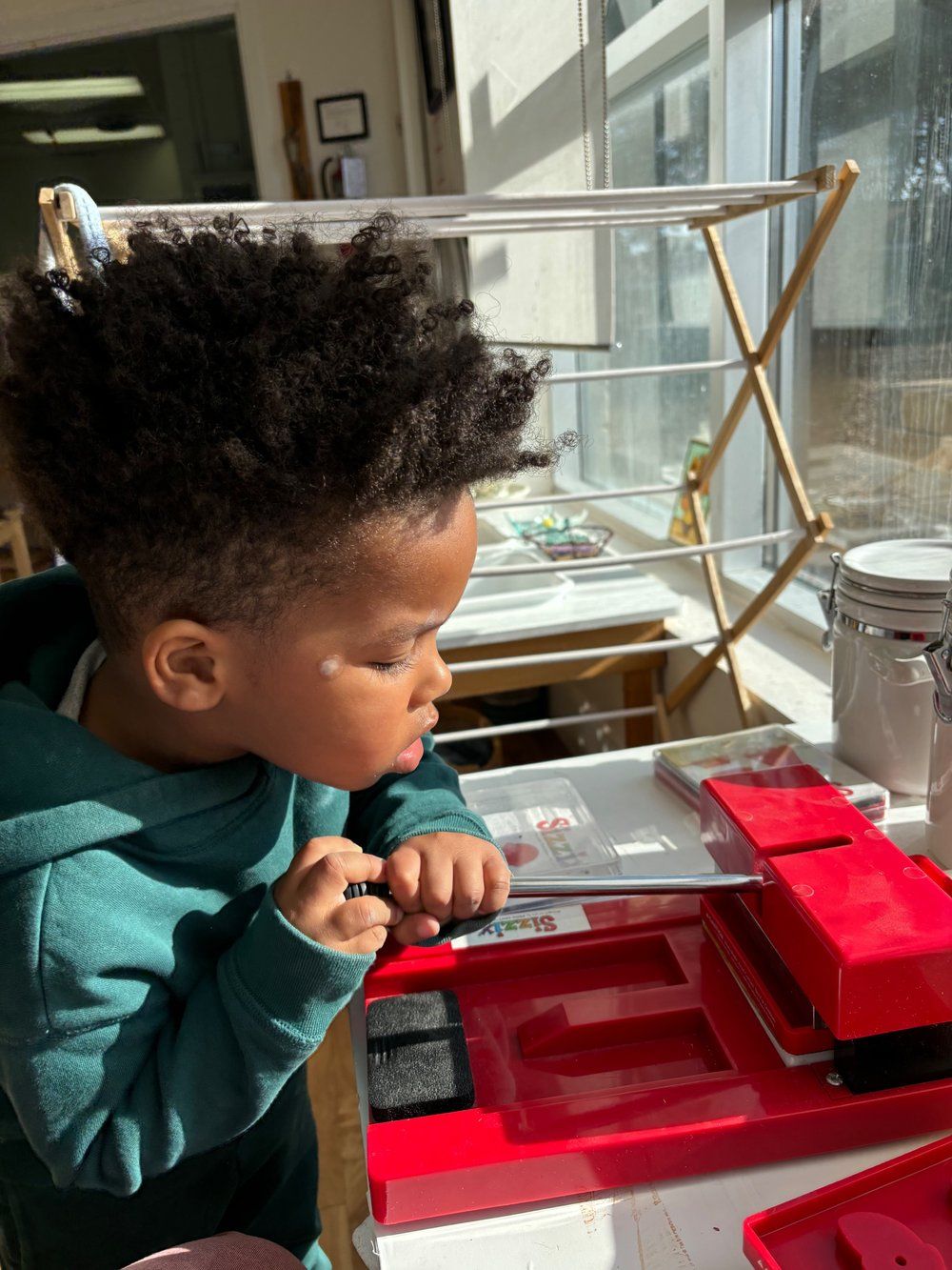 A young boy is sitting at a table playing with a toy.