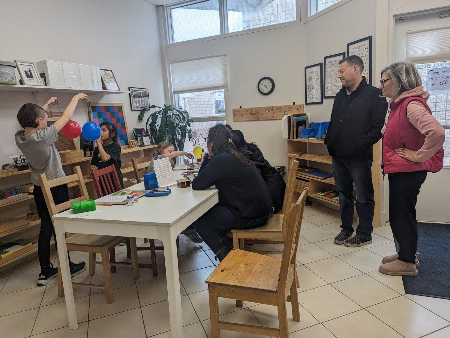 A group of people are standing around a table in a room.