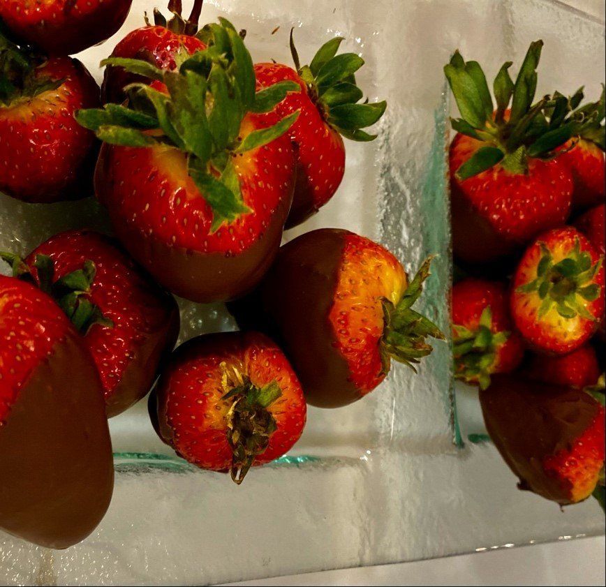 Strawberries dipped in chocolate on a glass plate