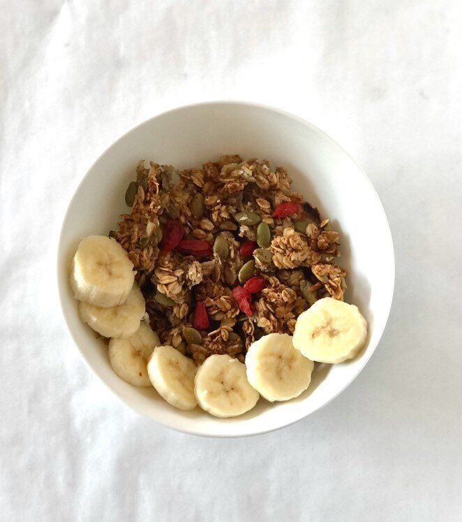 A bowl of granola with bananas and pumpkin seeds