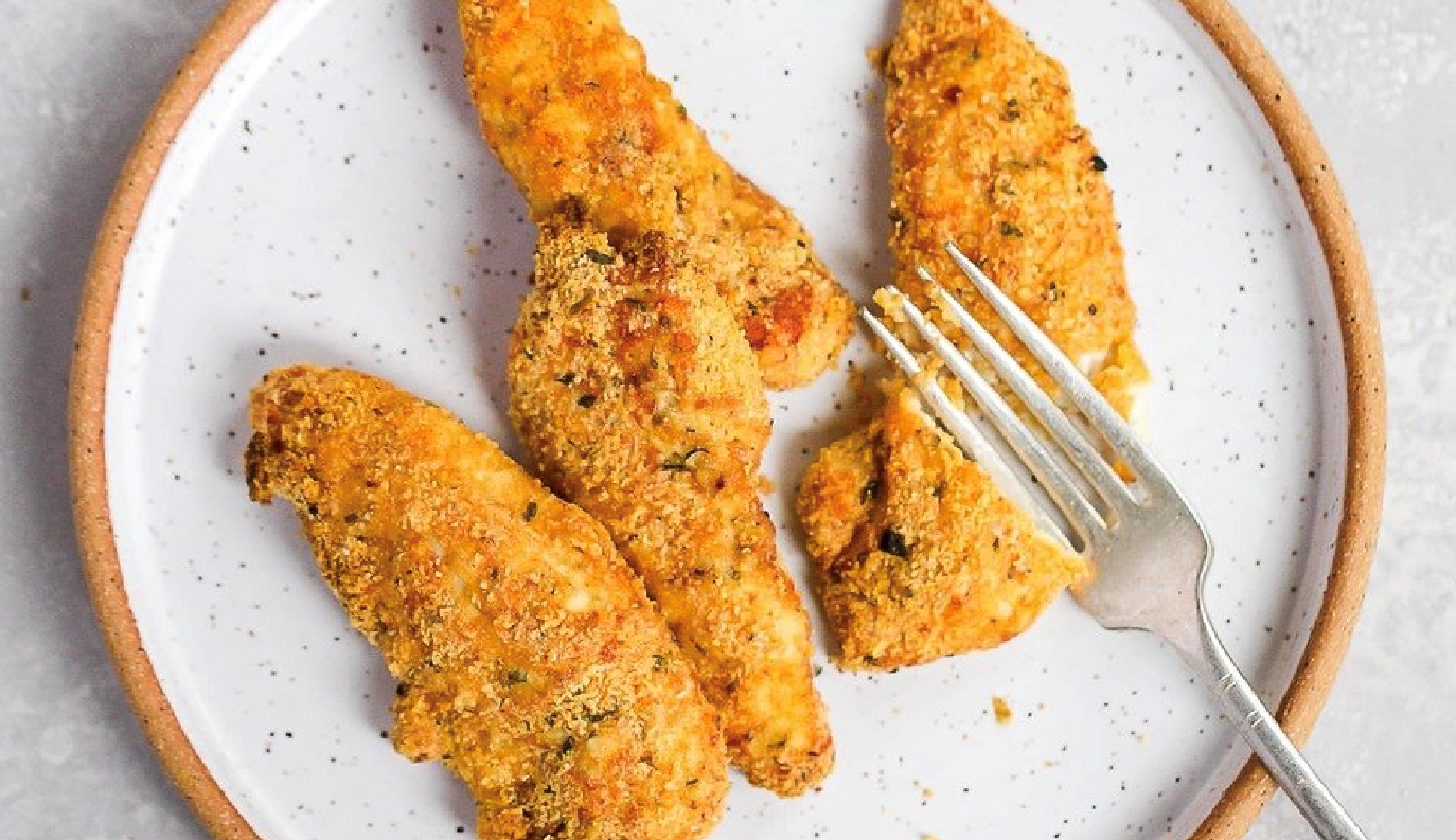 A plate of chicken strips with a fork on it.