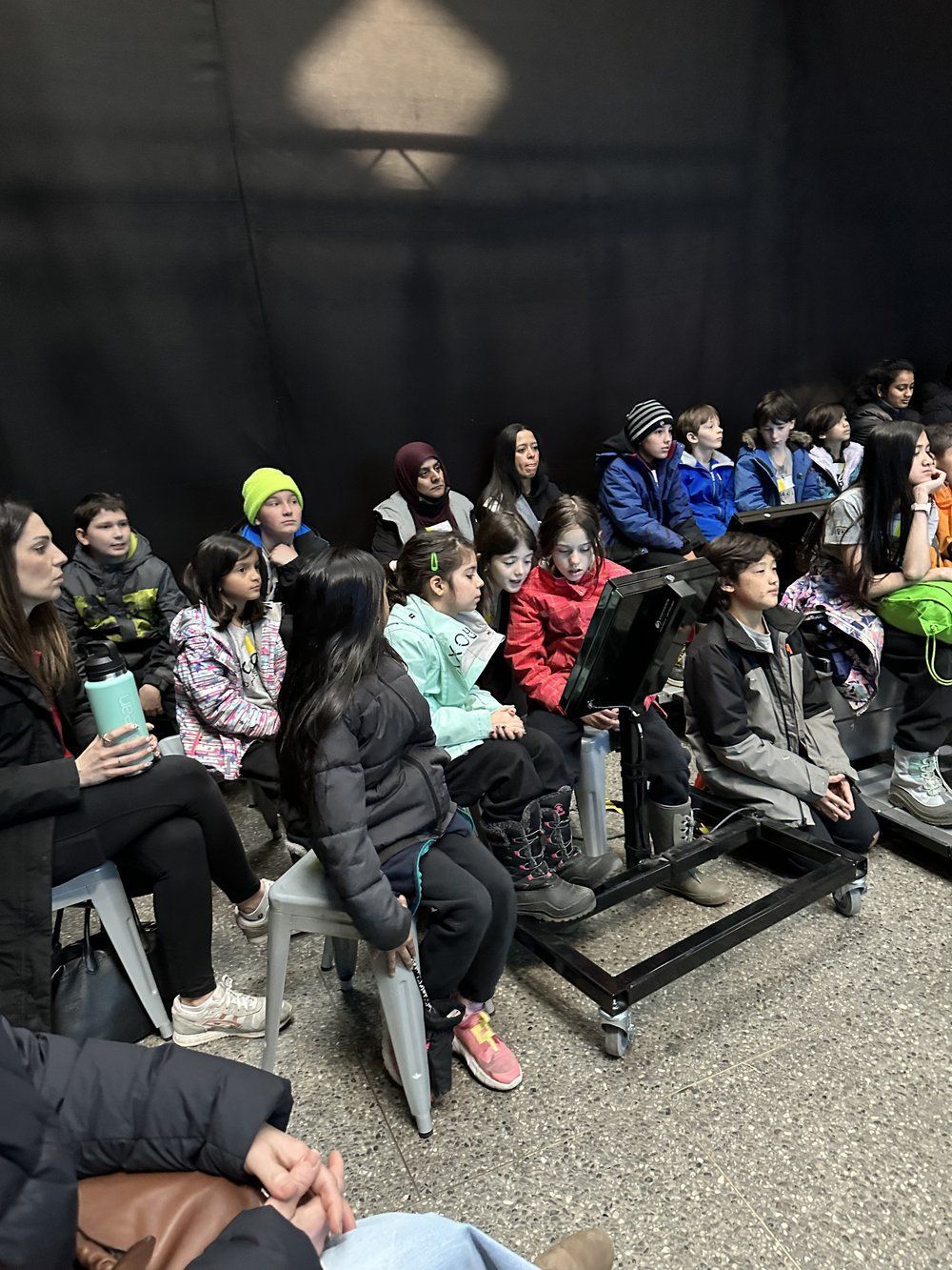 A group of people are sitting in a dark room.