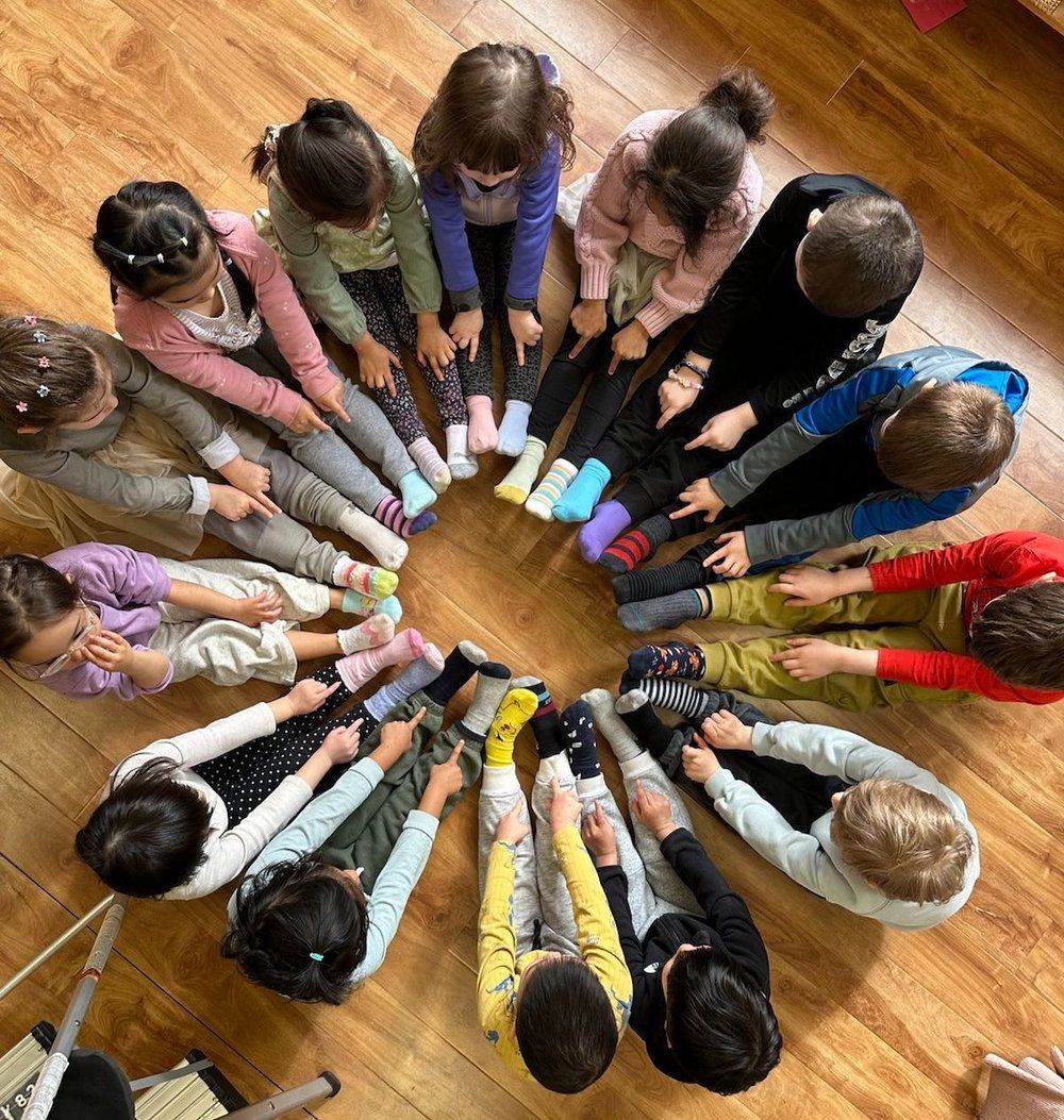 A group of children are sitting in a circle on the floor.