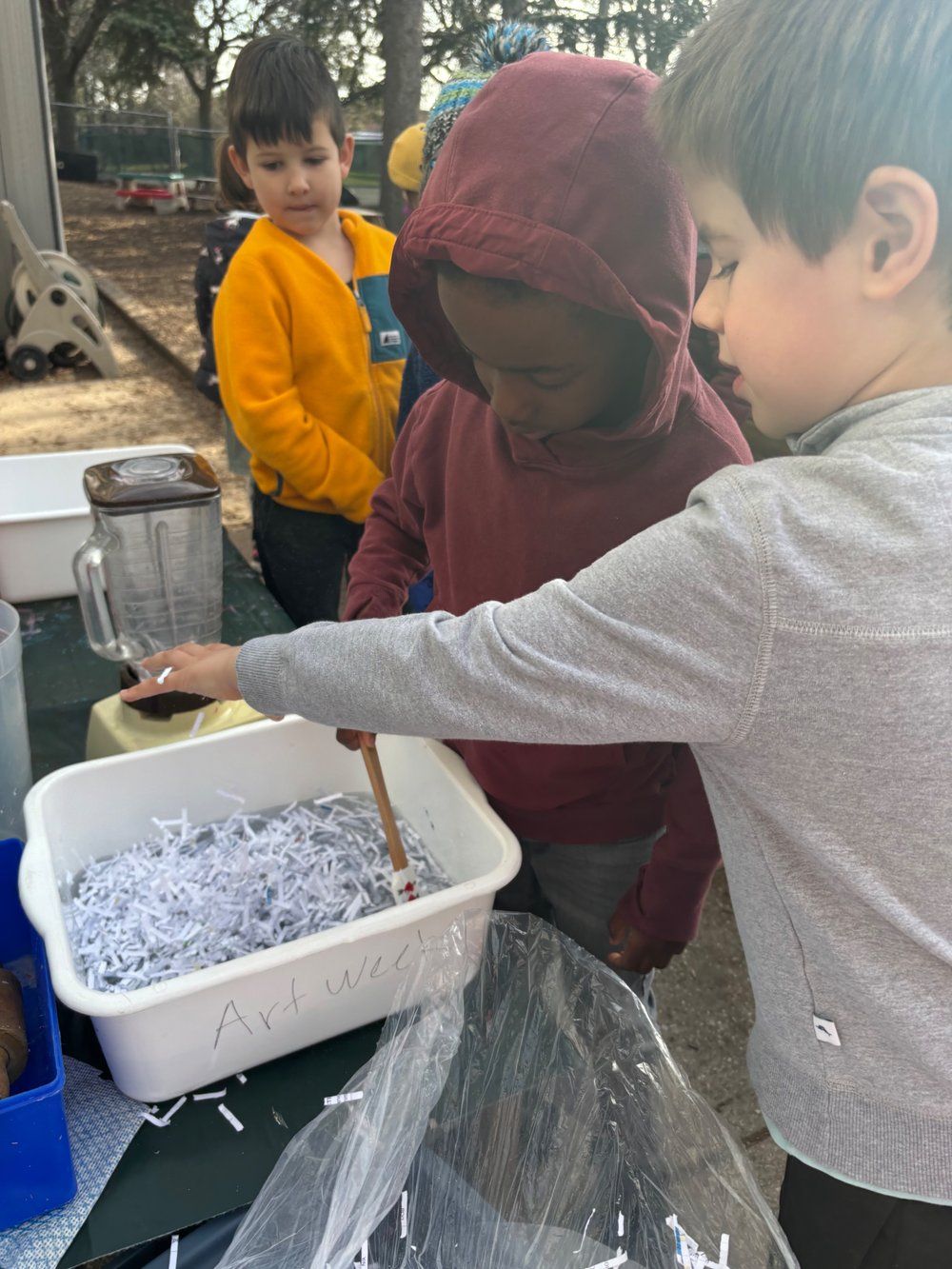 A group of young boys are playing with shredded paper
