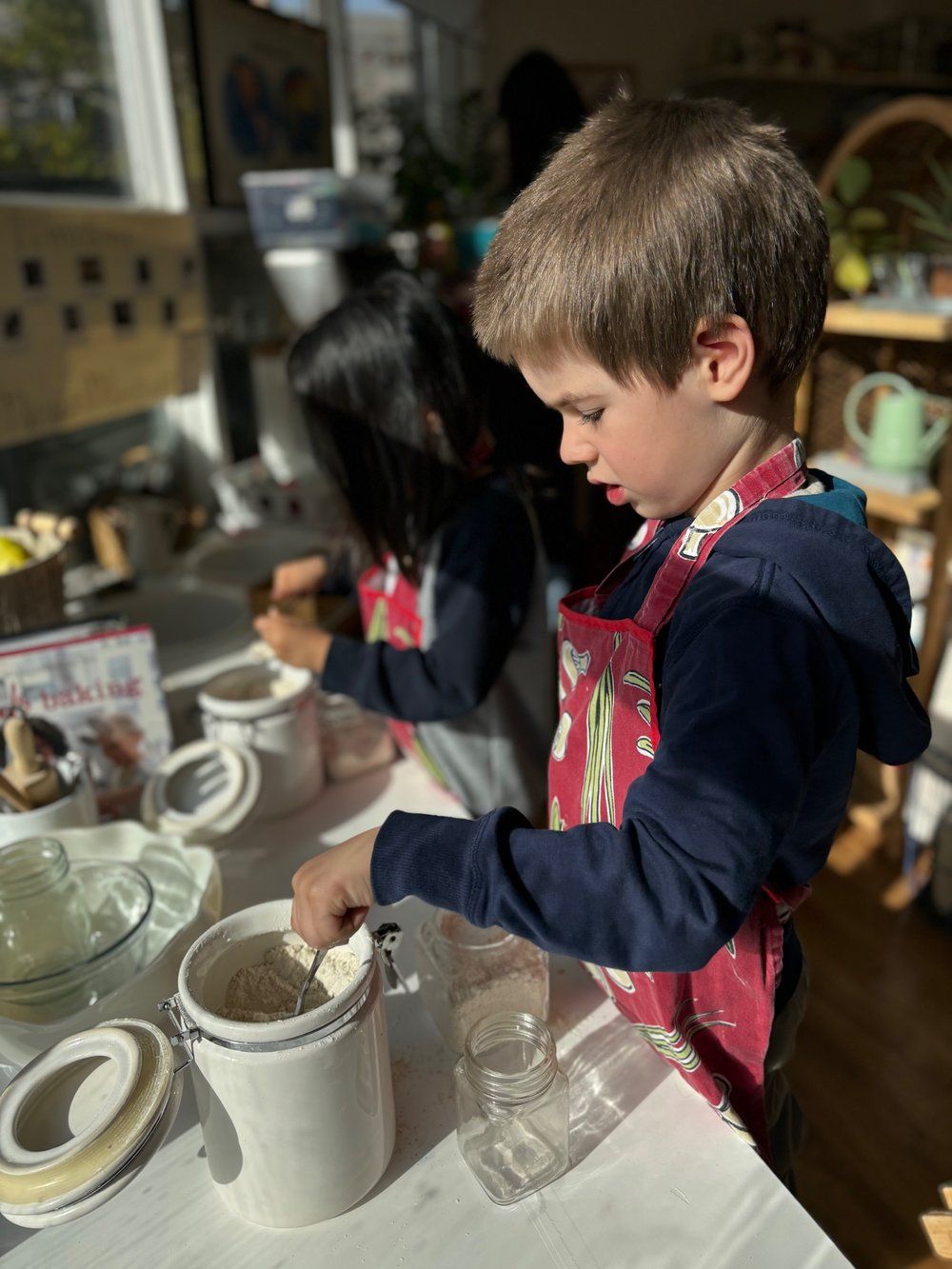 A boy and a girl are sitting at a table playing with clay.