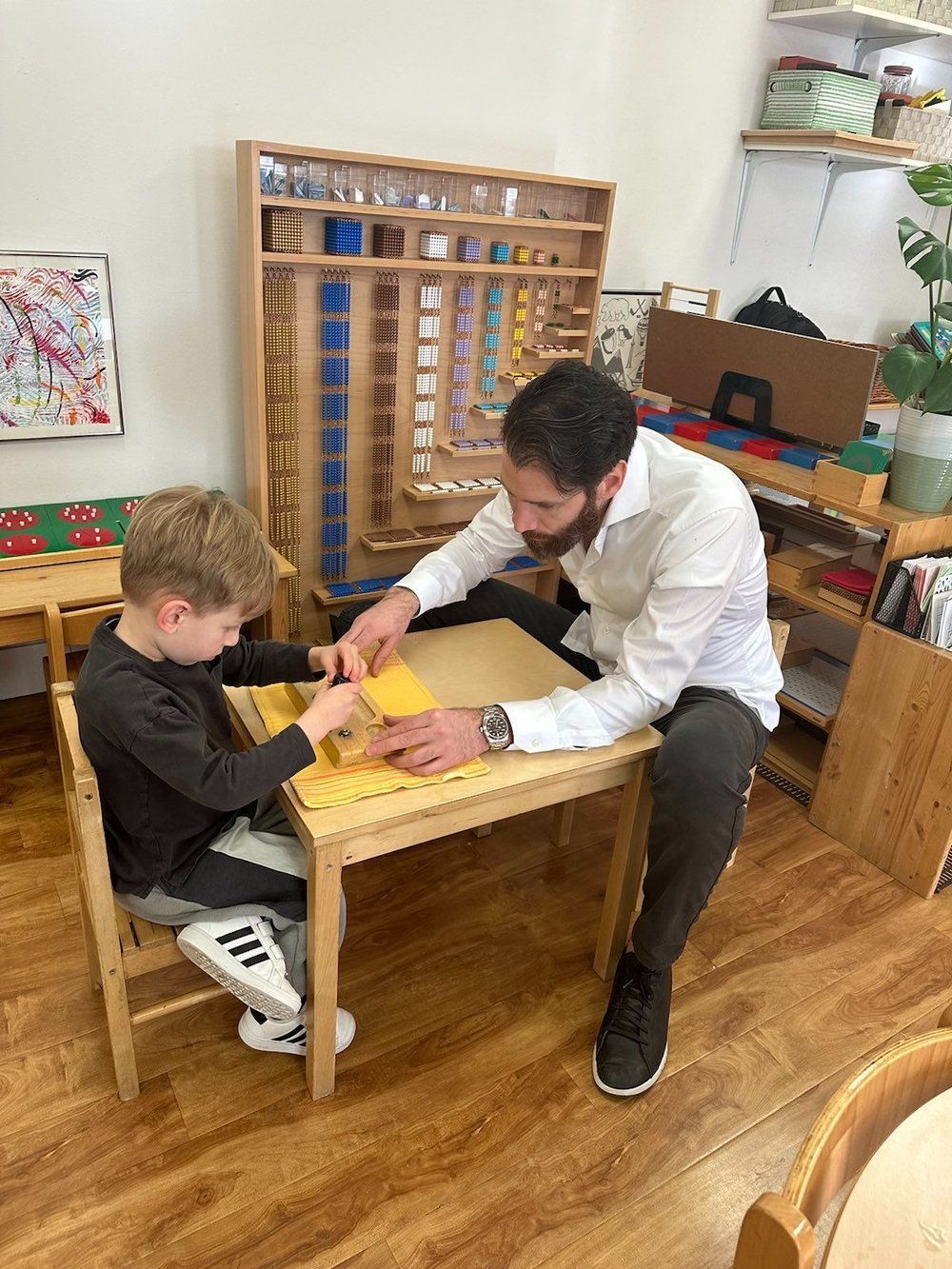 A man is sitting at a table with a child.