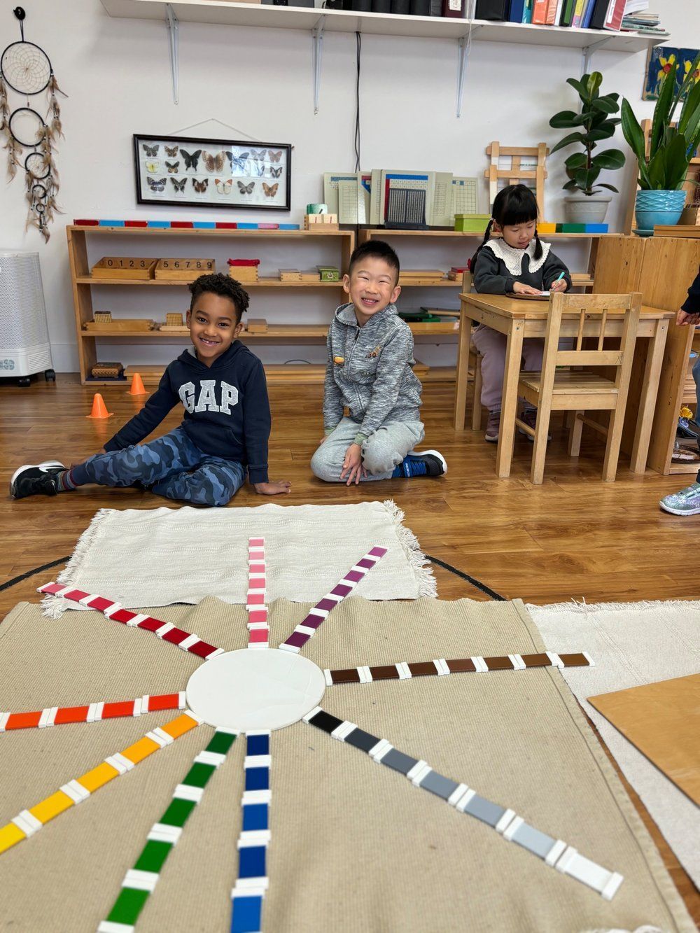 A group of children are sitting on the floor in a classroom.