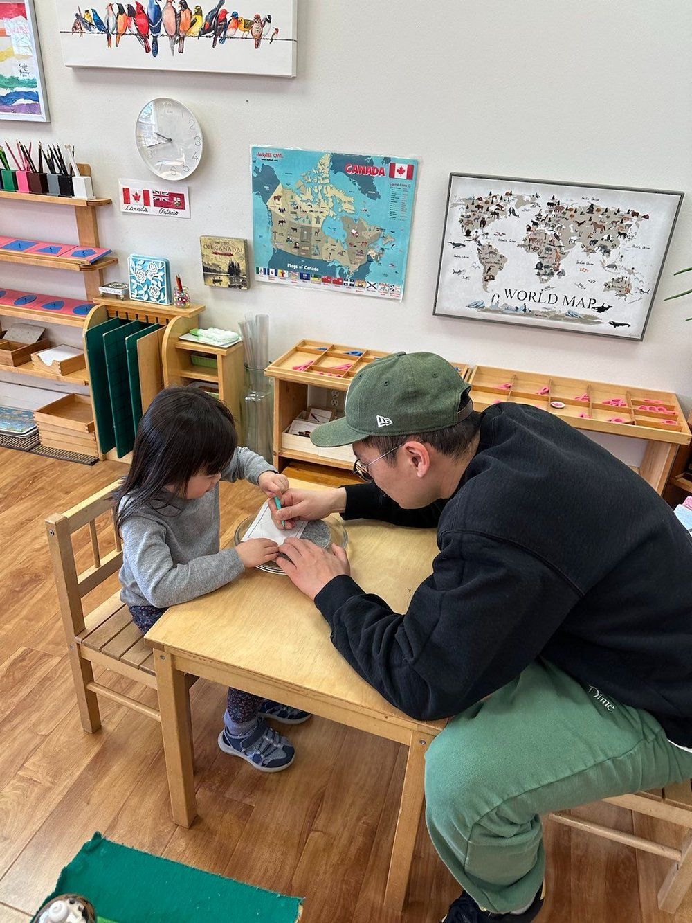 A man is sitting at a table with a little girl.