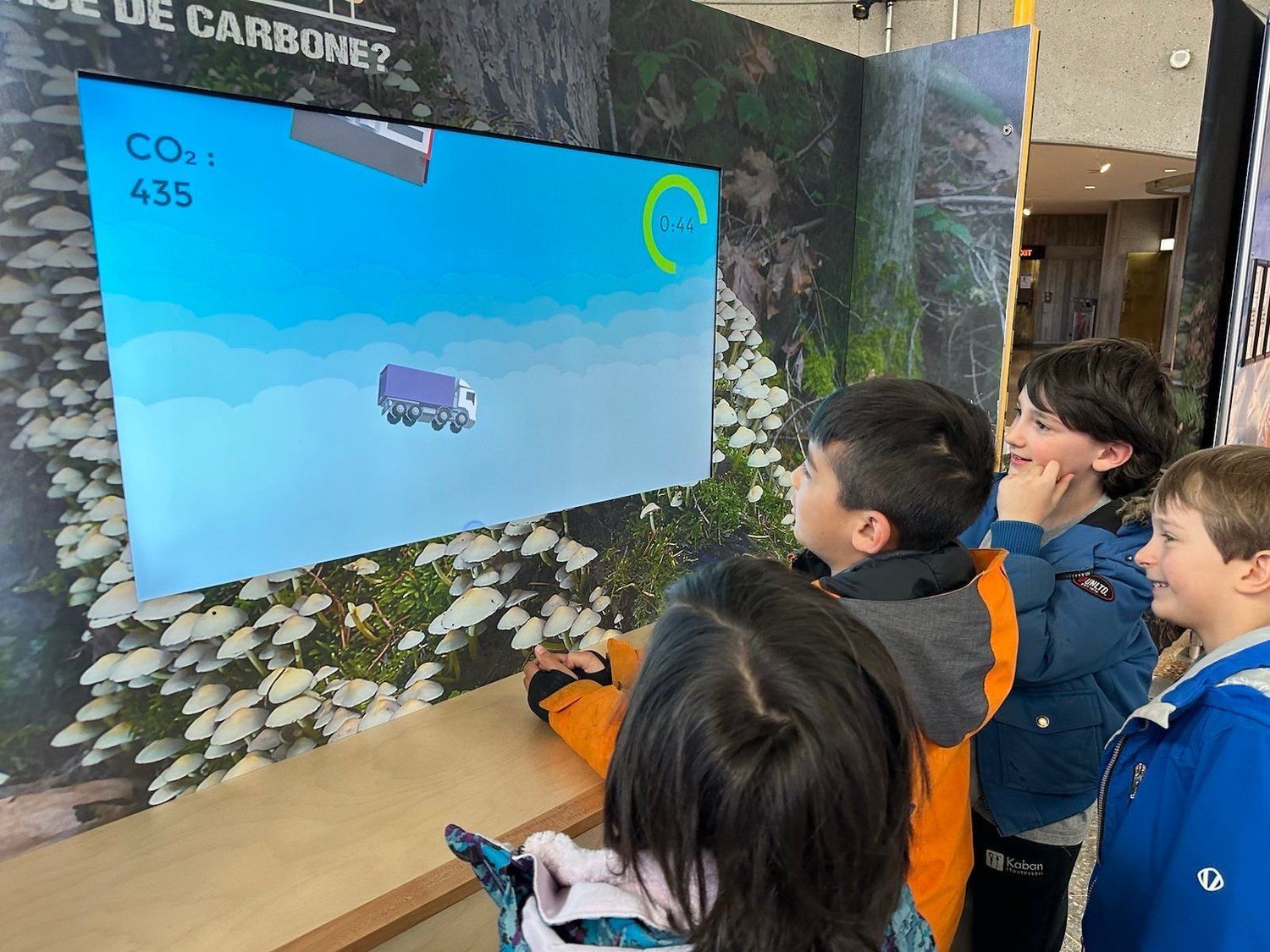 A group of children are playing a game on a large screen.