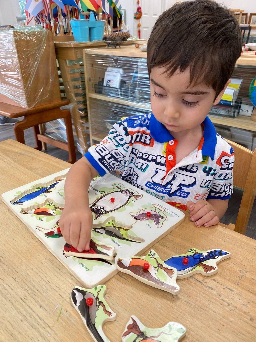 A young boy is playing with a puzzle on a table.