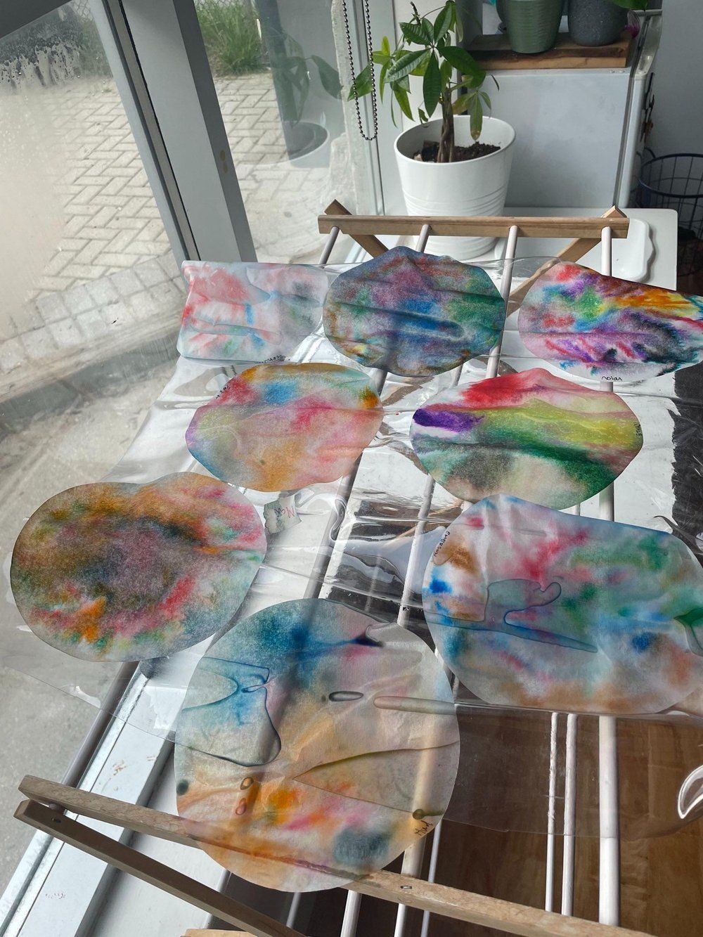 A bunch of colorful plates sitting on top of a window sill.