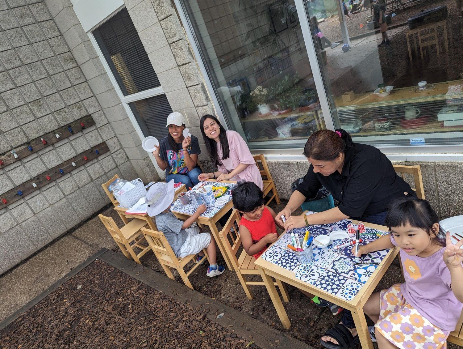 A group of people are sitting at tables outside of a building.