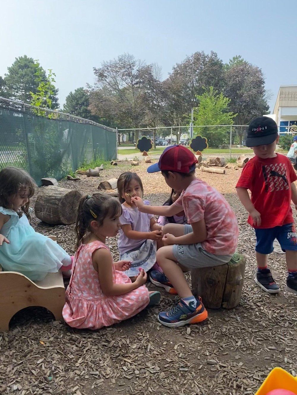 A group of children are playing in the dirt in a playground.