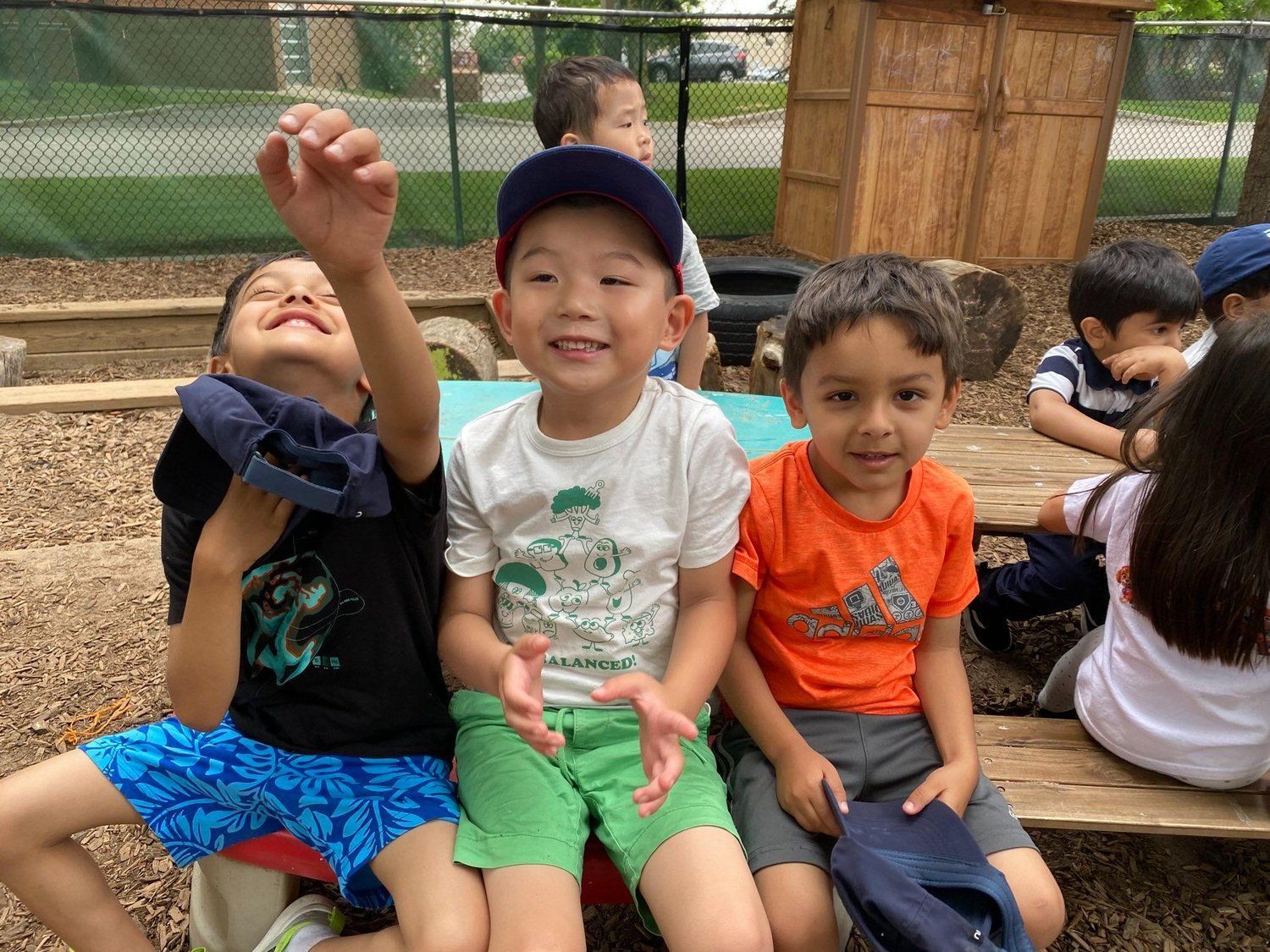 A group of young boys are sitting at a picnic table.