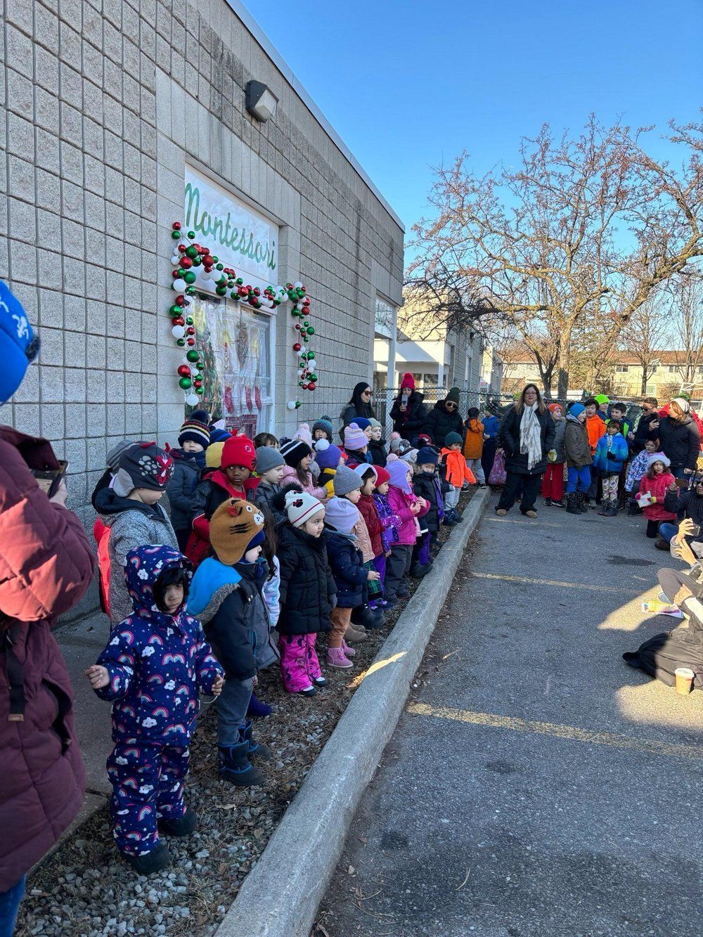 A group of children are standing in front of a building.