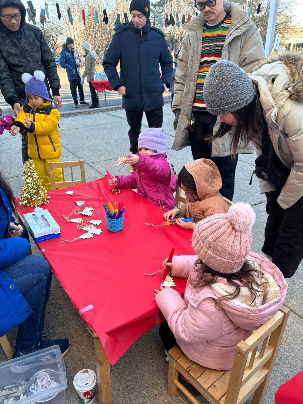 A group of children are sitting at a table outside.