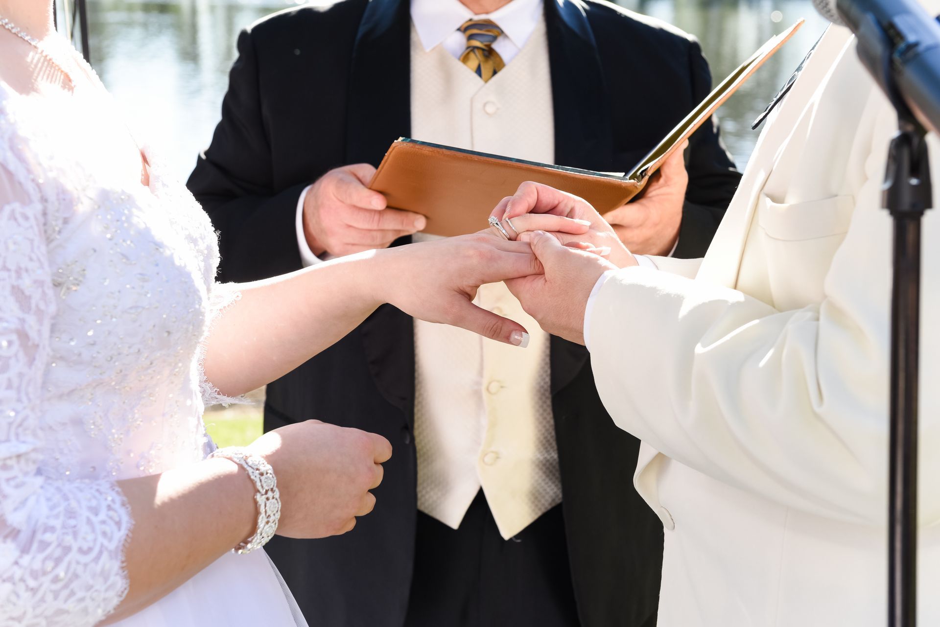 Wedding ceremony with an officiant holding vows as the couple joins hands.